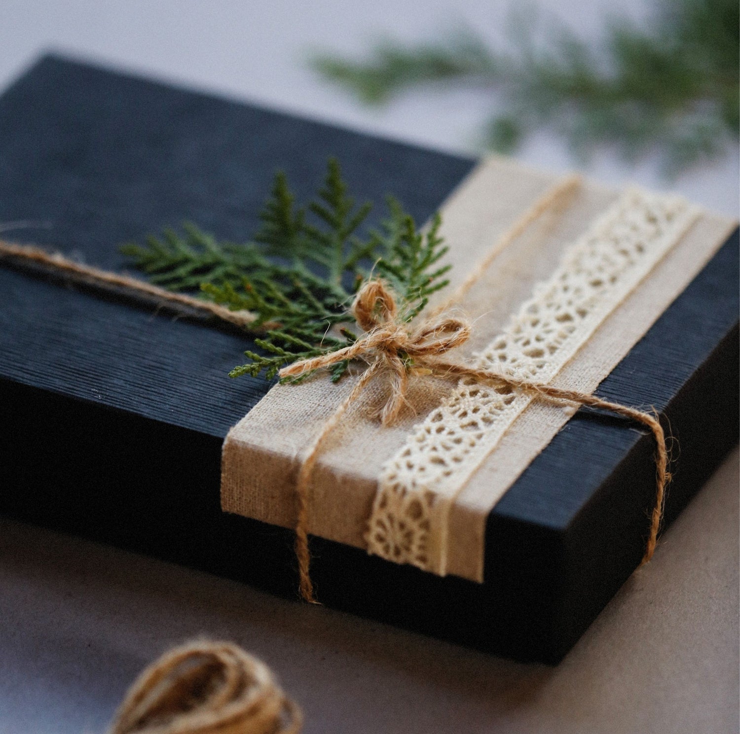 Elegant black gift box wrapped with eco-friendly lace and jute ribbon - perfect for corporate wellness gifting or bulk mental well-being orders by Guiding Koi.