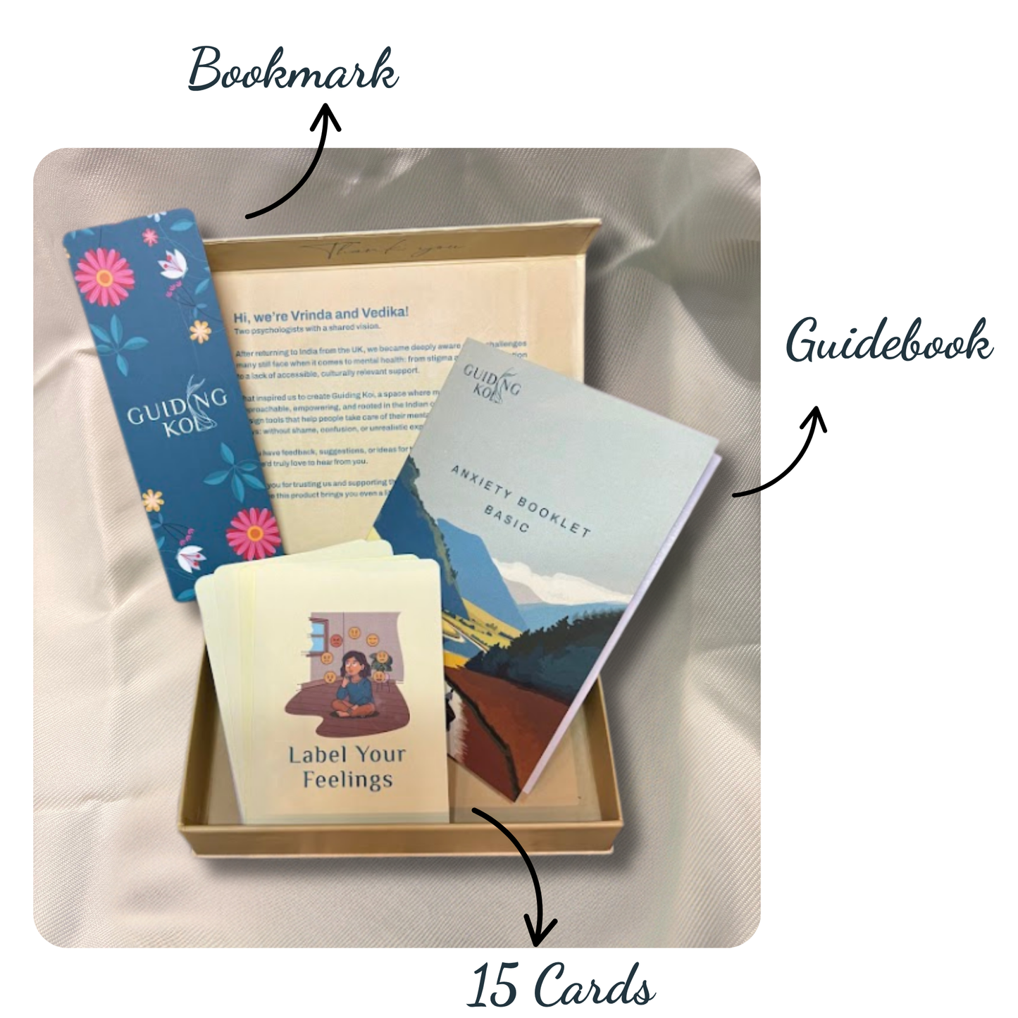 Open Guiding Koi Calm Deck box displaying 15 mindfulness cards, a blue floral bookmark, and an Anxiety Booklet guidebook - tools designed by psychologists for stress and anxiety relief.
